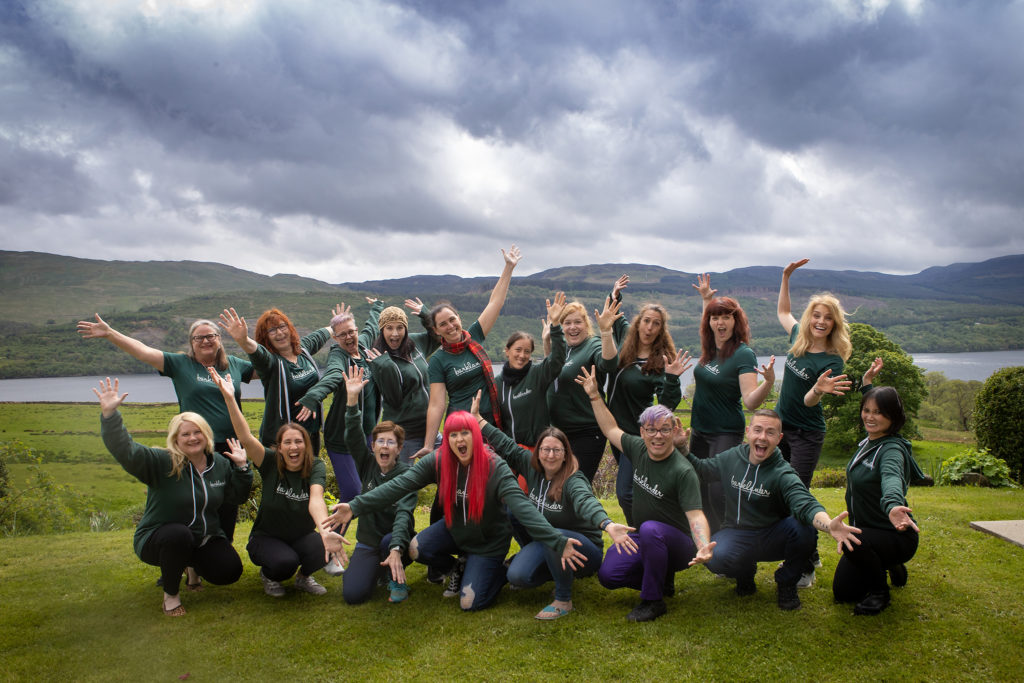 group of excited people in front of mountain