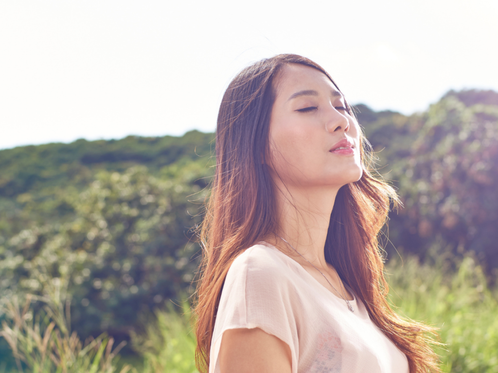 woman closing her eyes outside