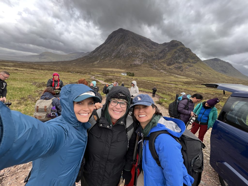 three women doing a selfie in front of a mountain