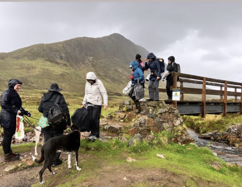 people wearing raincoats by mountains