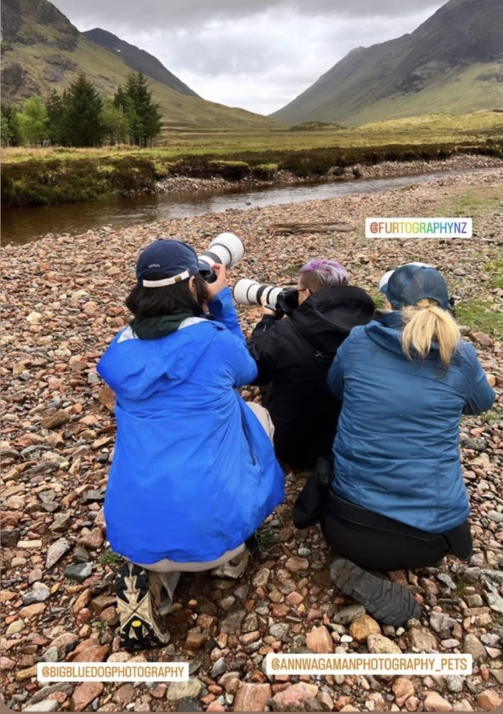 three photographers sitting on rocks