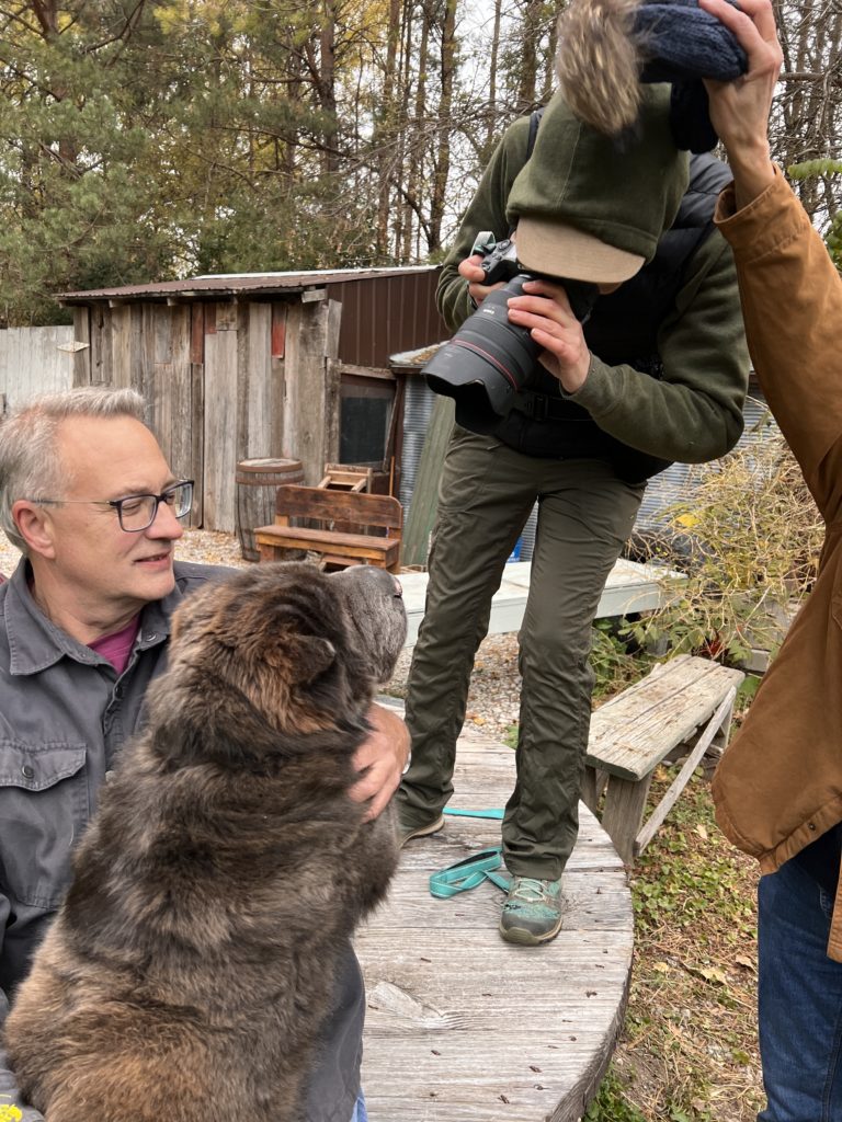 woman taking a picture of a brown dog