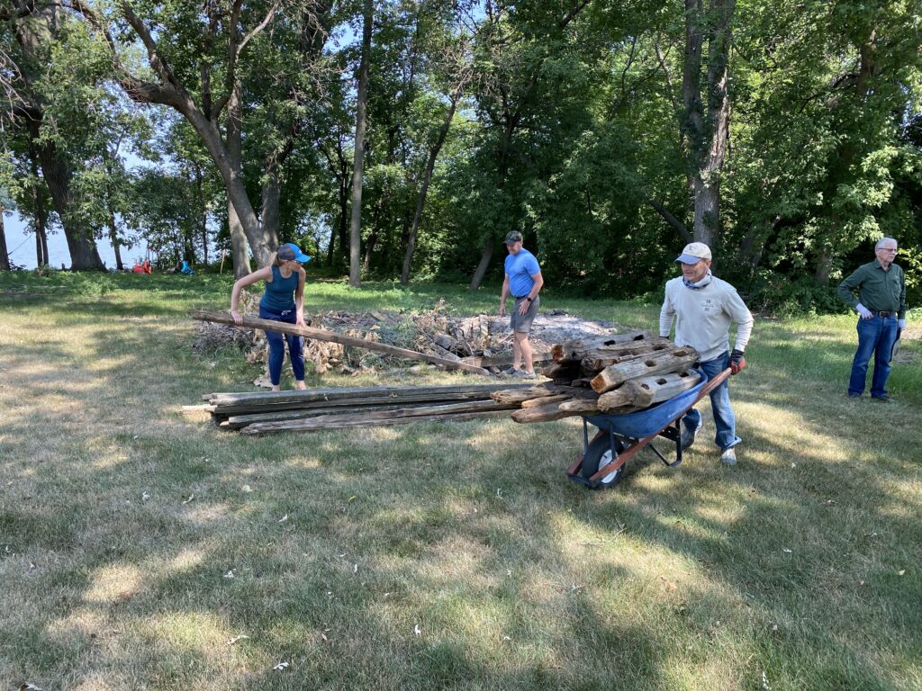 4 people moving fence posts outside